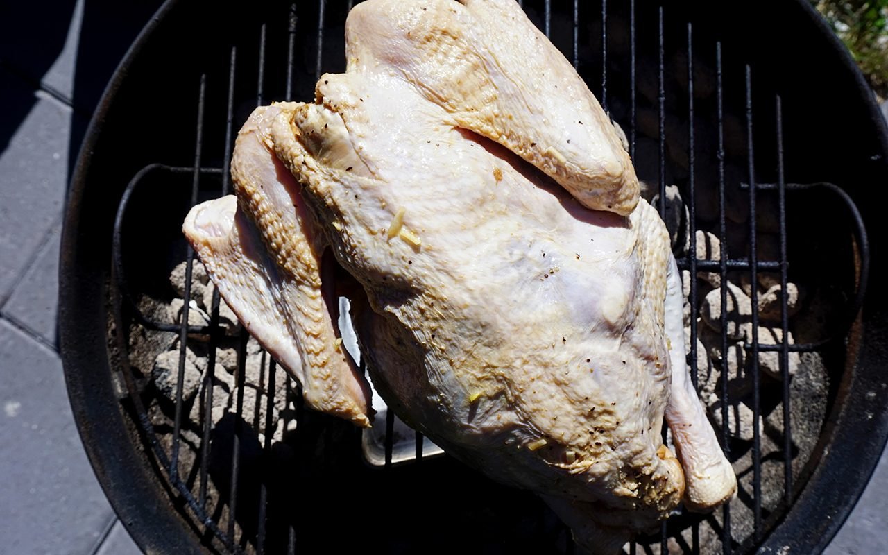 placing the turkey onto the grill breast side down