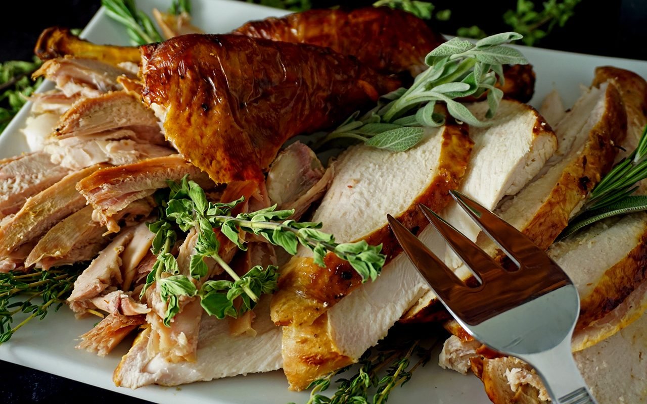 angled view of carved grilled turkey on a platter