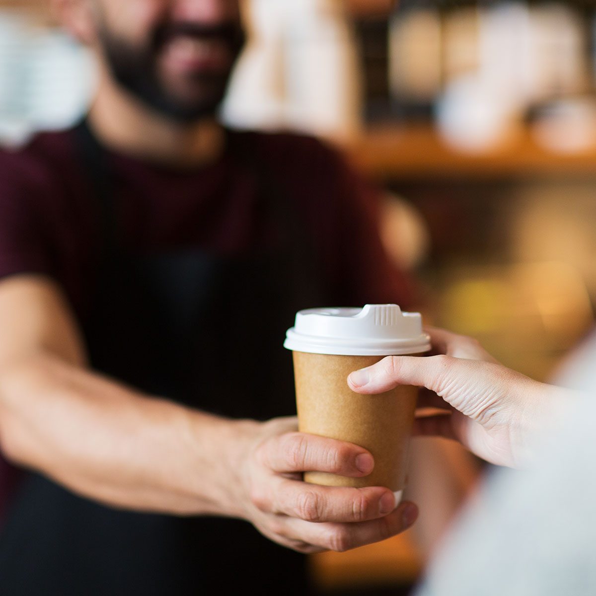 small business, people and service concept - man or bartender serving customer at coffee shop