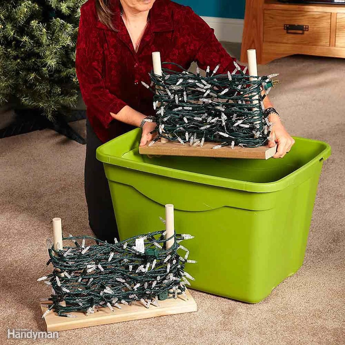 Storing Christmas lights wrapped around wooden pegs and being put into a lime green plastic tub