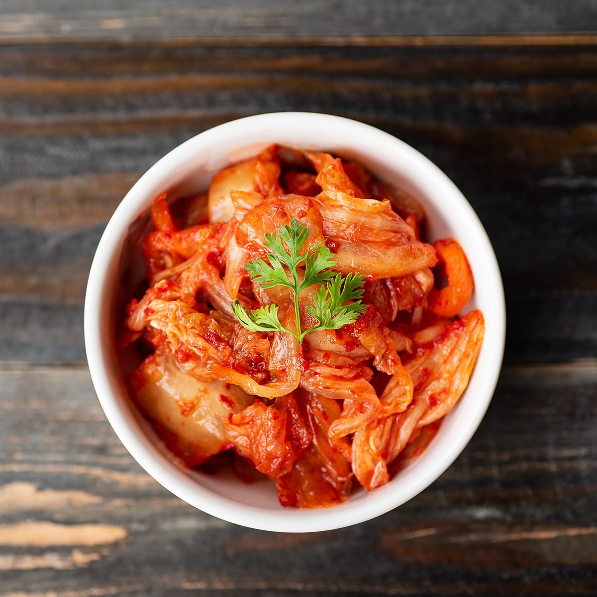 Kimchi cabbage in a bowl on wooden background