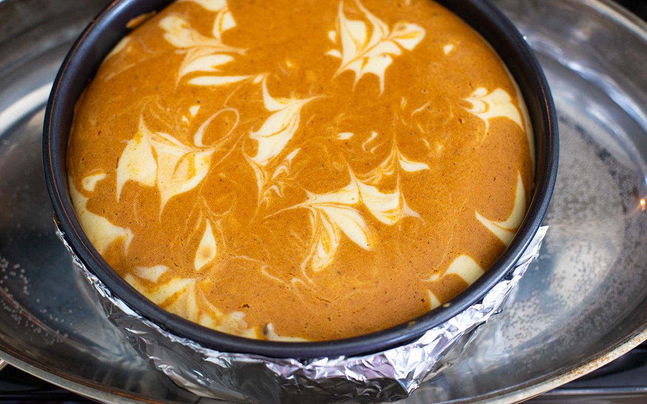 Cheesecake in roasting pan for baking.