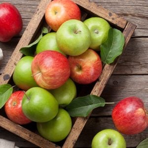 Ripe green and red apples in wooden box. Top view with space for your text