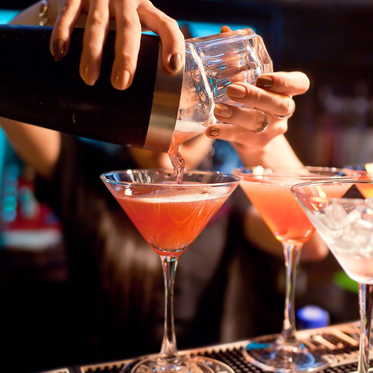 The girl bartender prepares a cocktail in the nightclub.