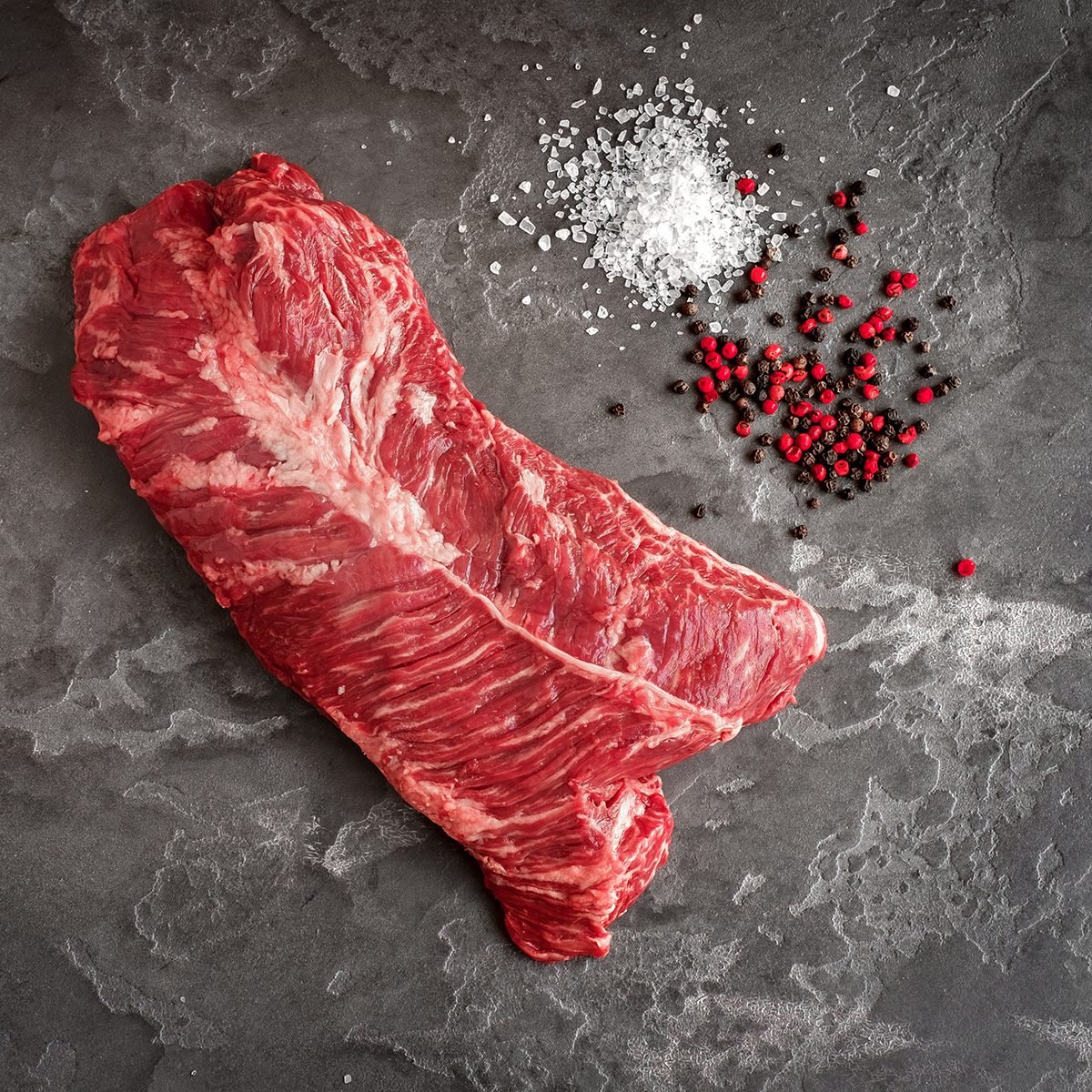hanger Tender steak on a stone background with salt and pepper