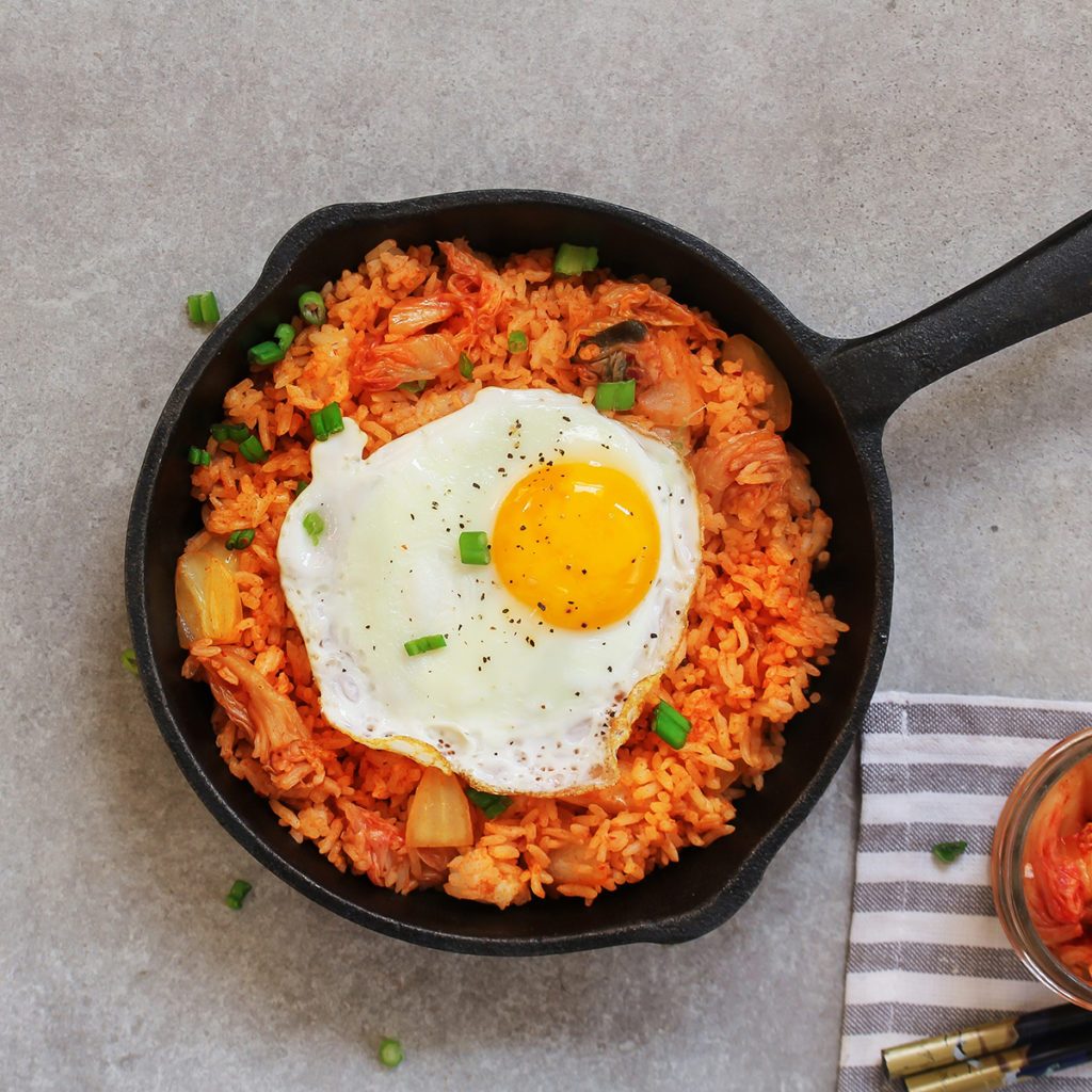 Homemade Kimchi Fried rice topped with fried egg on skillet, overhead view; Shutterstock ID 1254756118; Job (TFH, TOH, RD, BNB, CWM, CM): Taste of Home