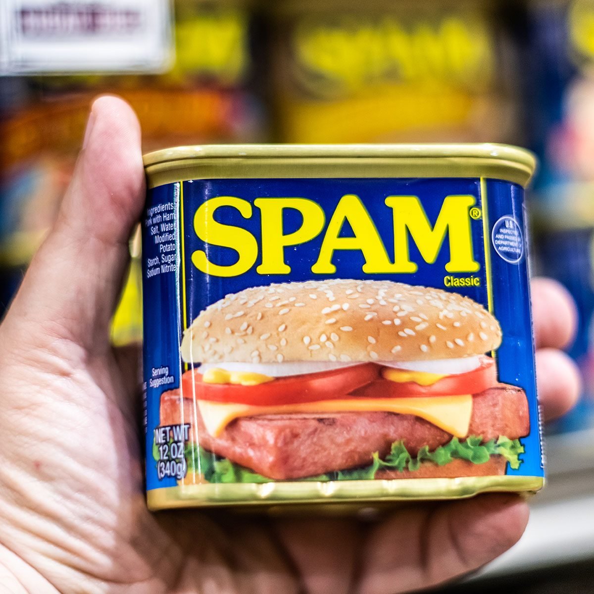 shoppers hand holding a can of SPAM brand canned meat