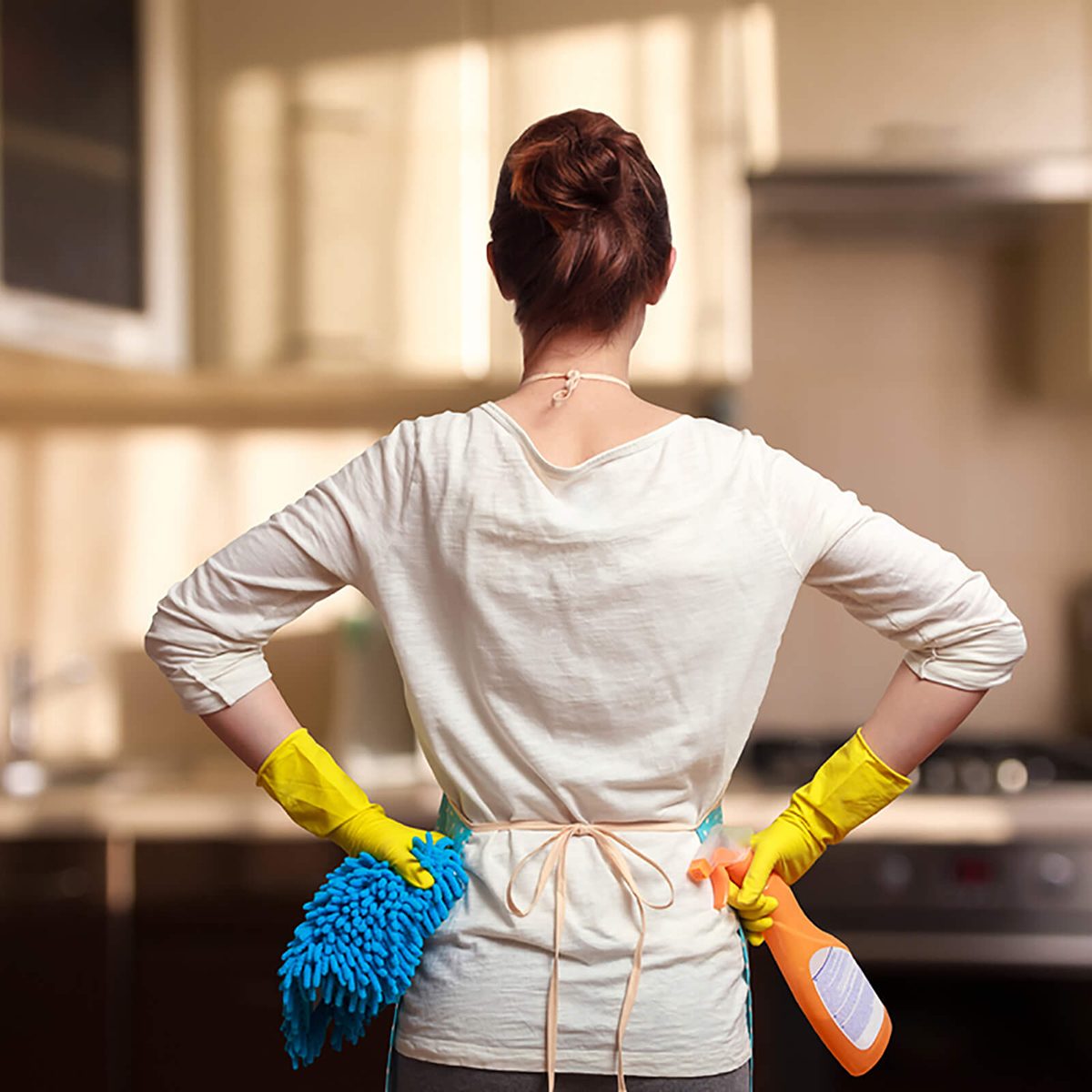 Young woman preparing to clean the kitchen. Standing back