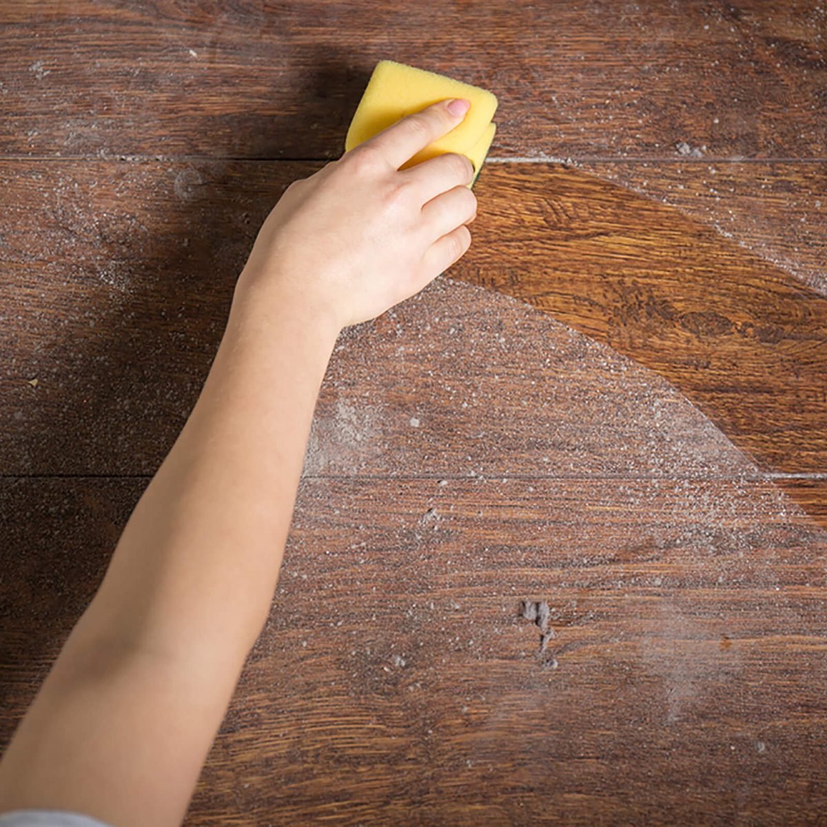 Using yellow sponge for cleaning dusty wood