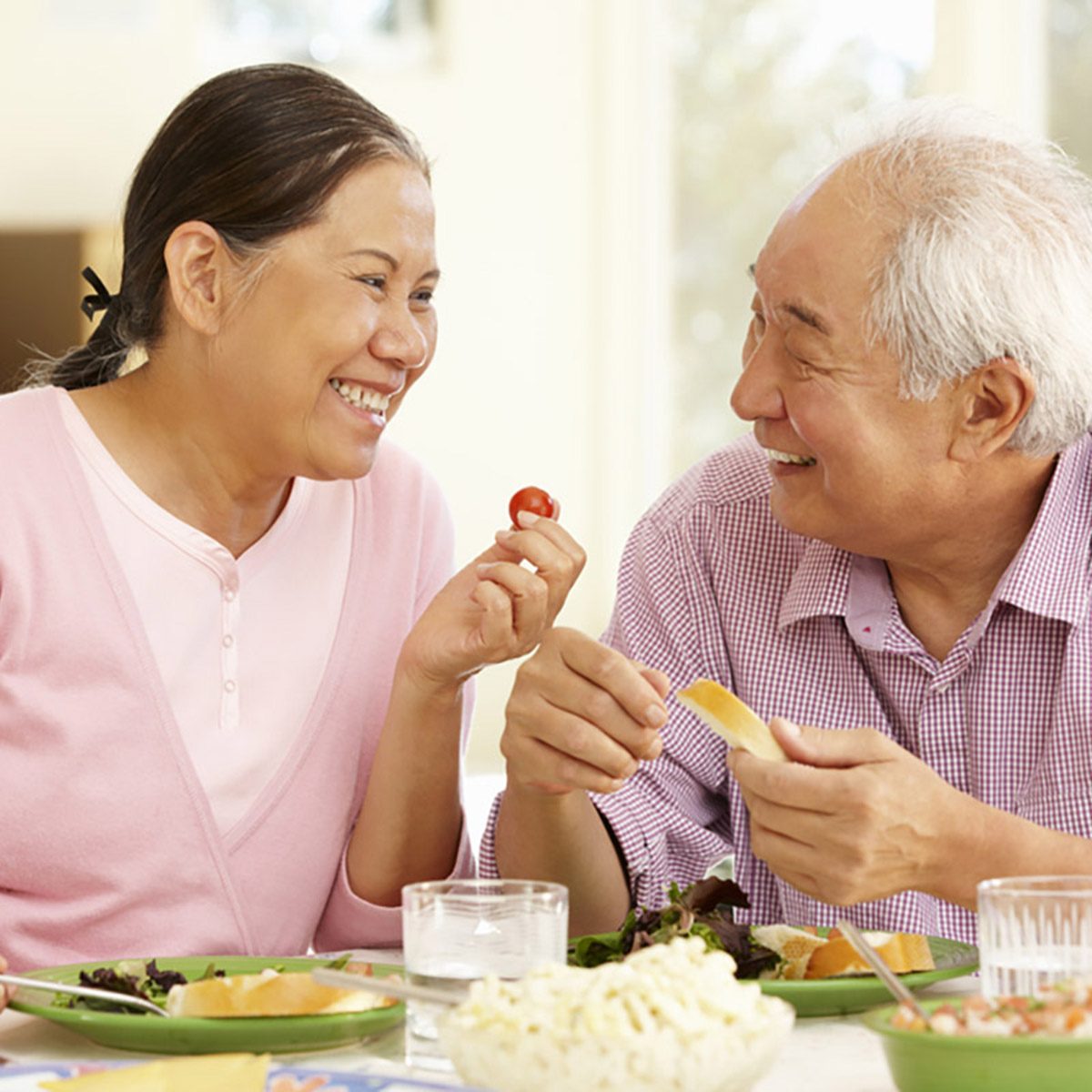 Senior asian couple sharing meal at home