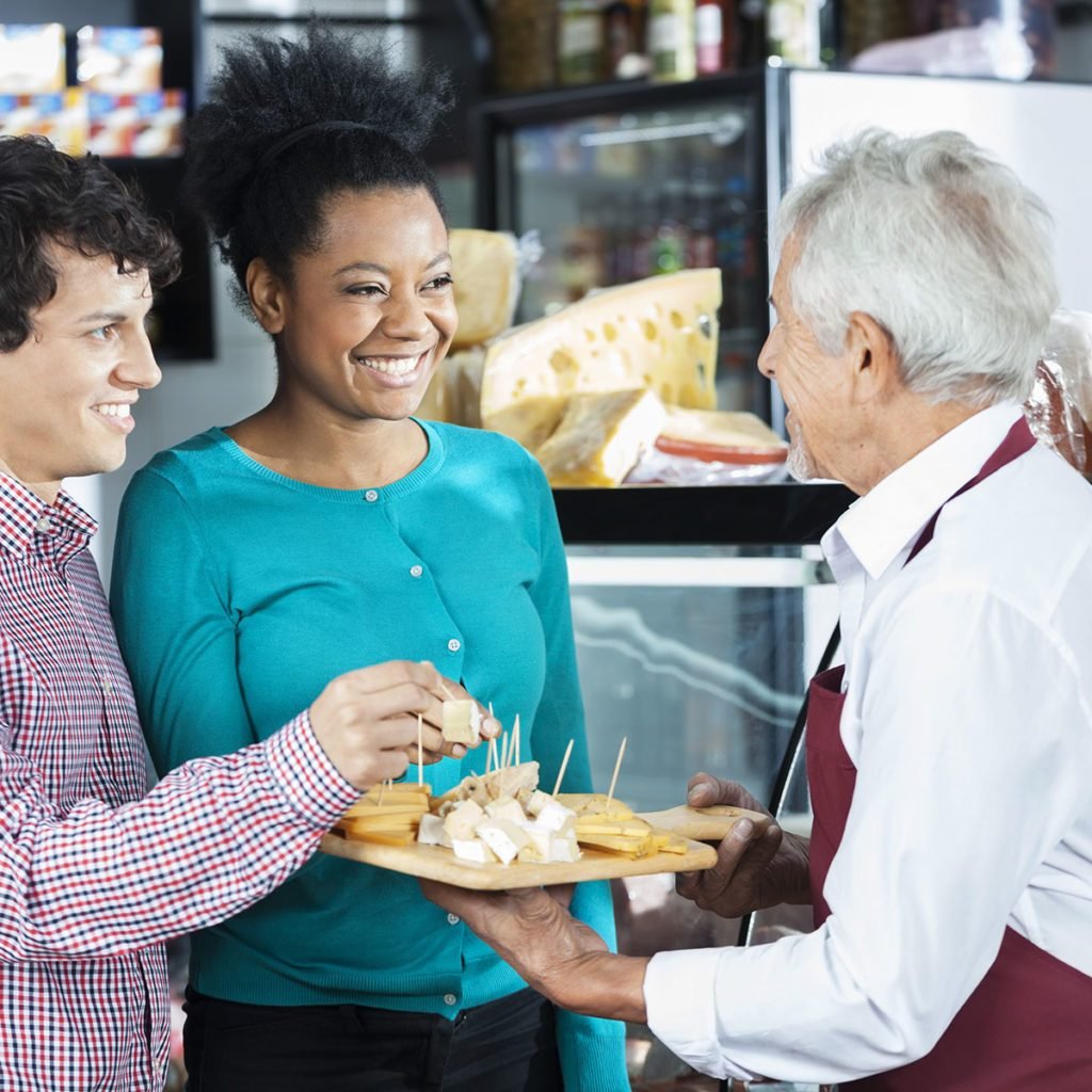 Salesman Offering Cheese Samples To Customers In Shop; Shutterstock ID 414153787; Job (TFH, TOH, RD, BNB, CWM, CM): TOH