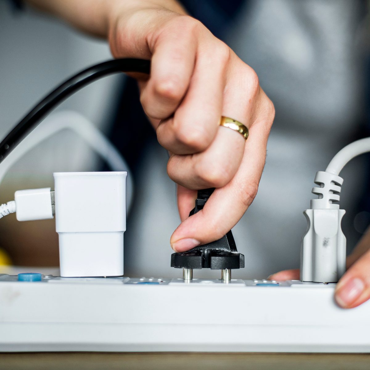 Woman plugging the wire to the outlet