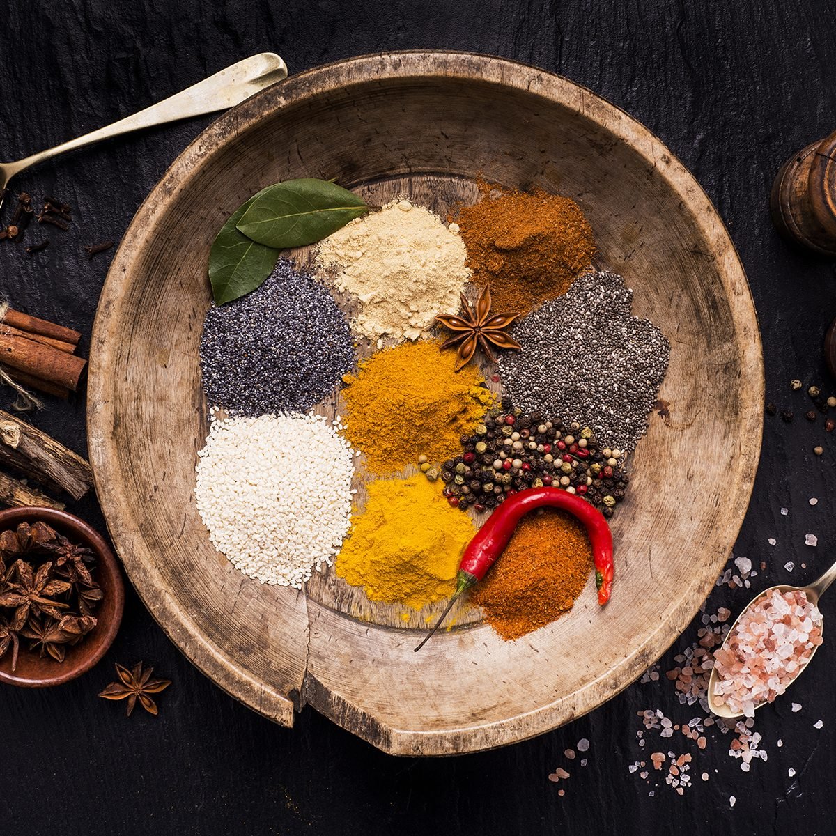 vintage wooden plate full of colorful spices and ingredients