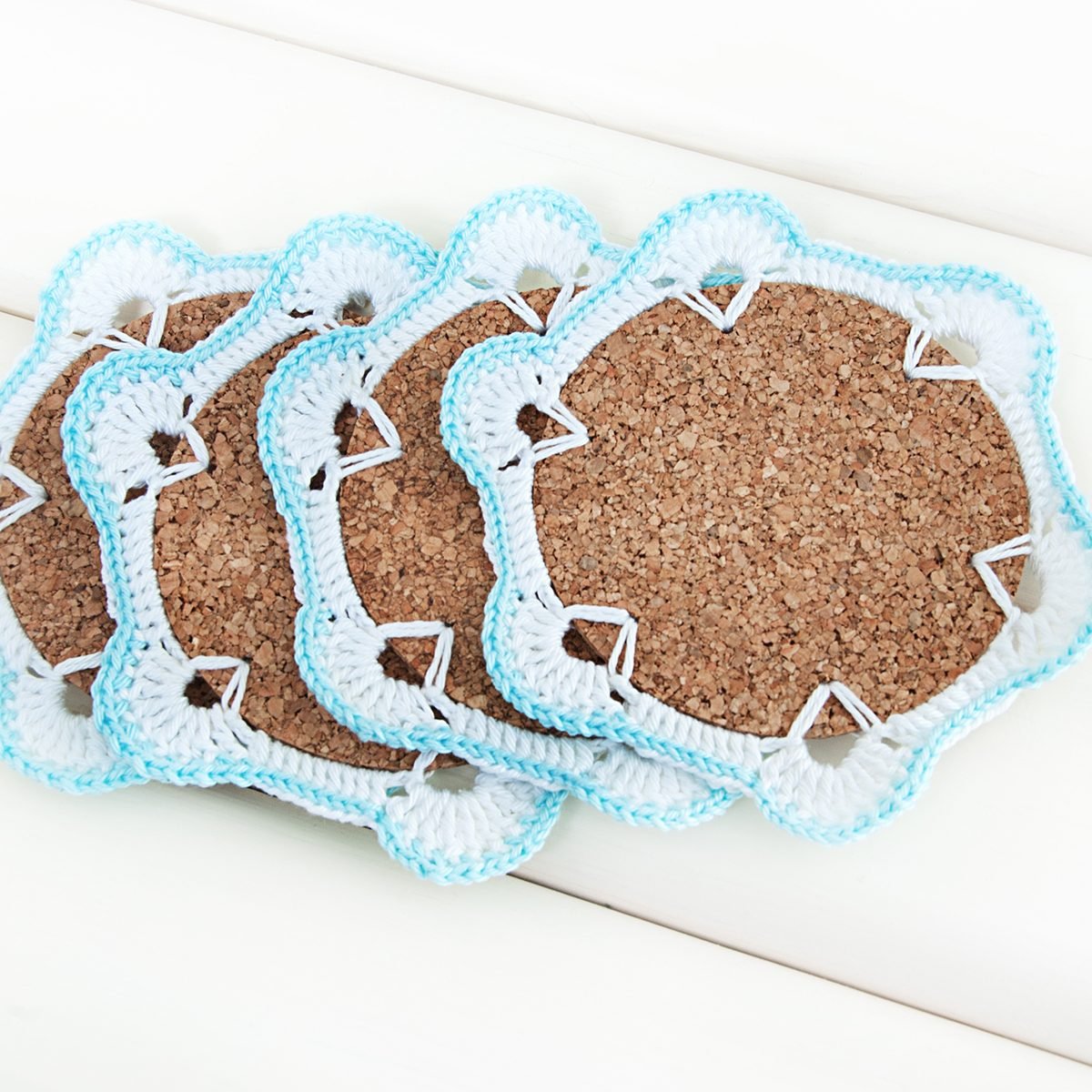 Crochet white and blue coaster with cork base