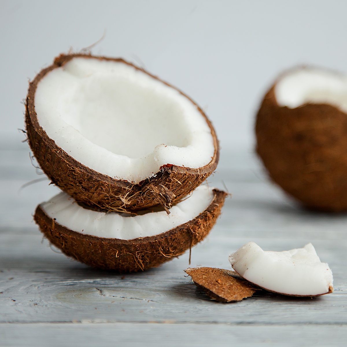 broken fresh organic coconut on rustic wooden grey background