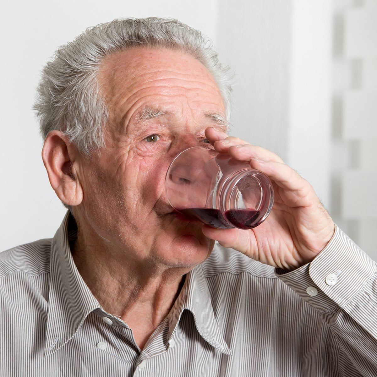 Close up of old man drinking blueberry juice