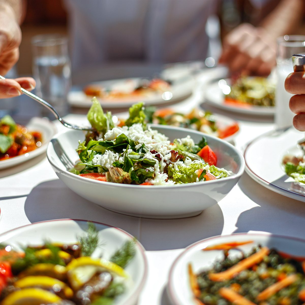 Couple Eating Lunch with Fresh Salad and Appetizers