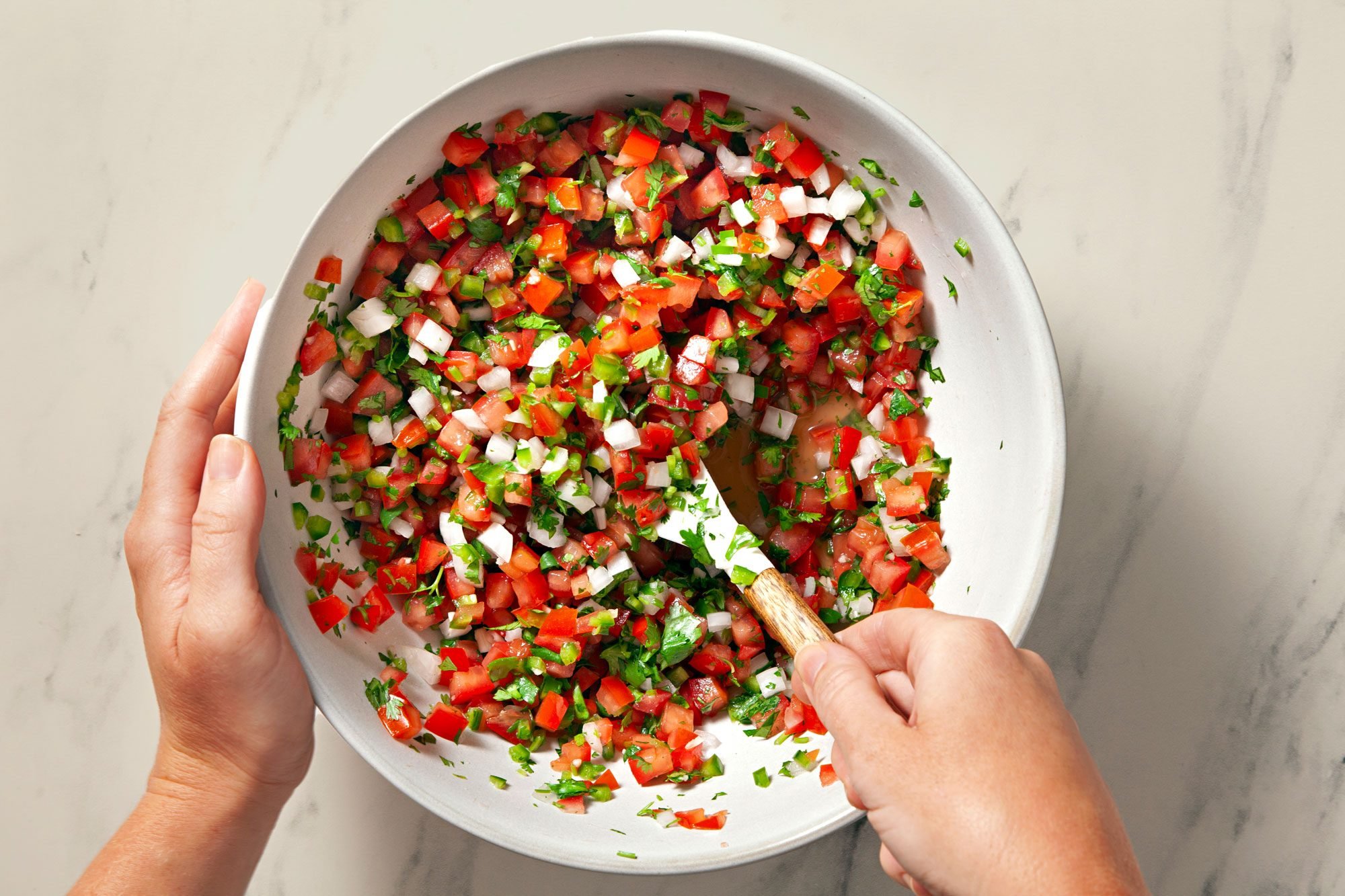 Overhead shot of same bowl; add 1/4 teaspoon salt; combine all ingredients; spatula; marble background;