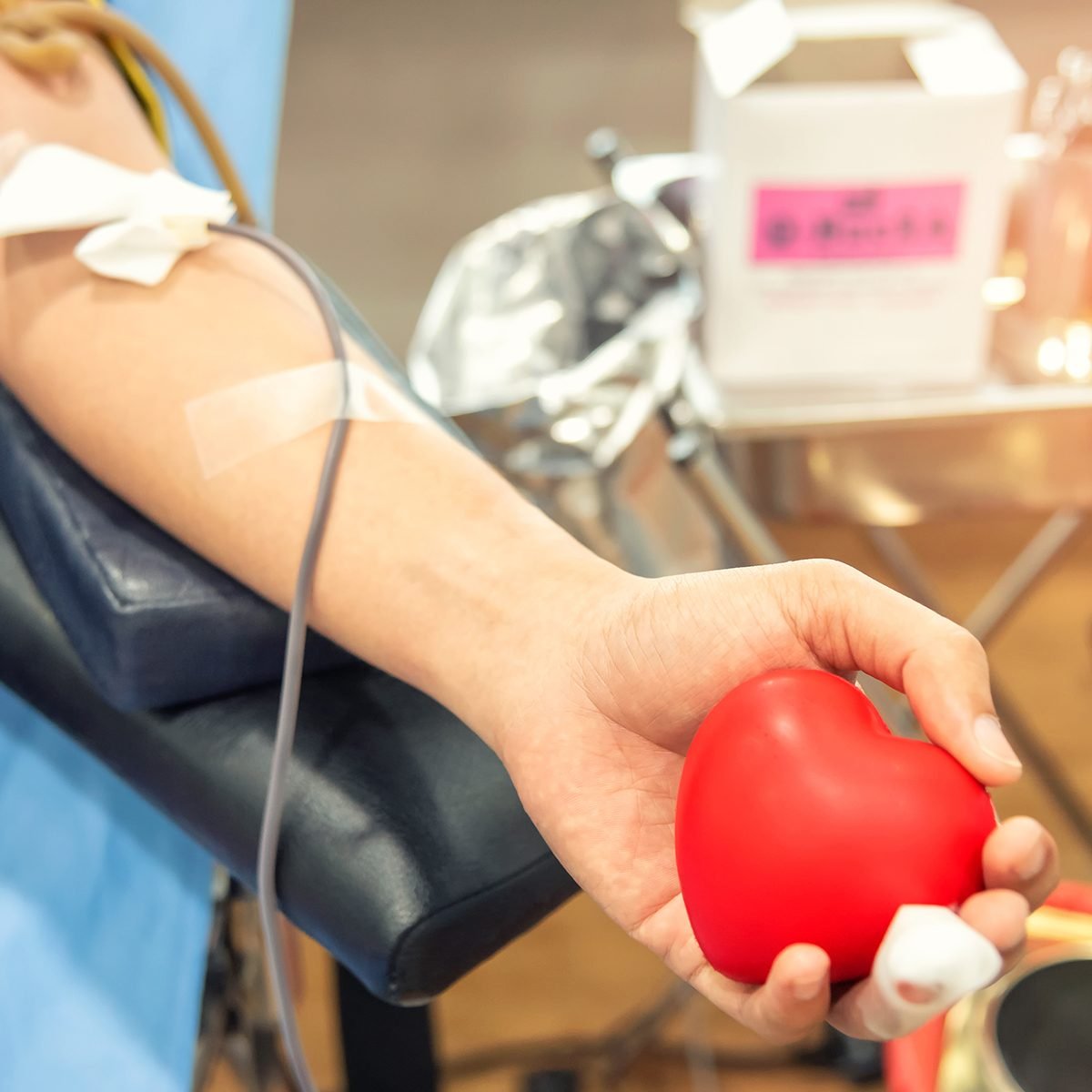 Blood donor at donation, transfusion. Closeup blood donor squeezes the bouncy ball in the form of heart in his hand. Healthcare and charity. Concept image for World blood donor day-June 14.