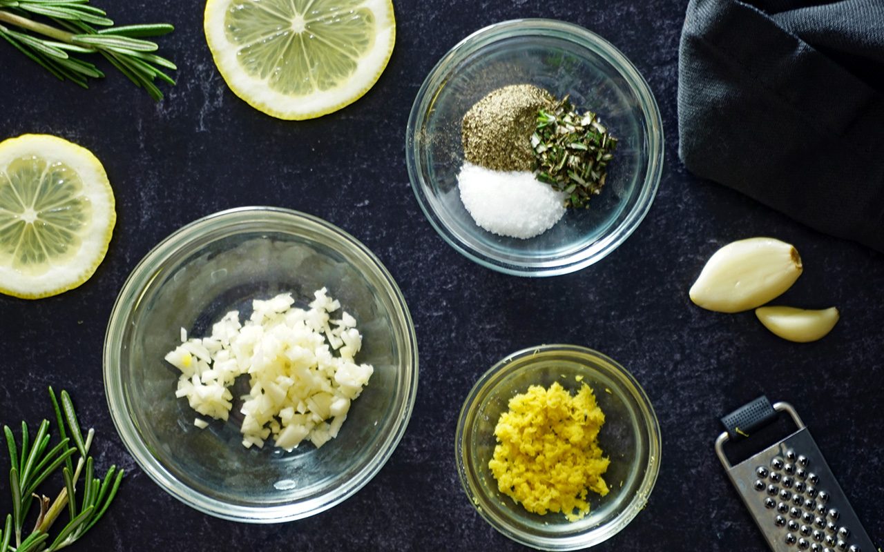 rub ingredients for grilled salmon in individual bowls on a slate counter