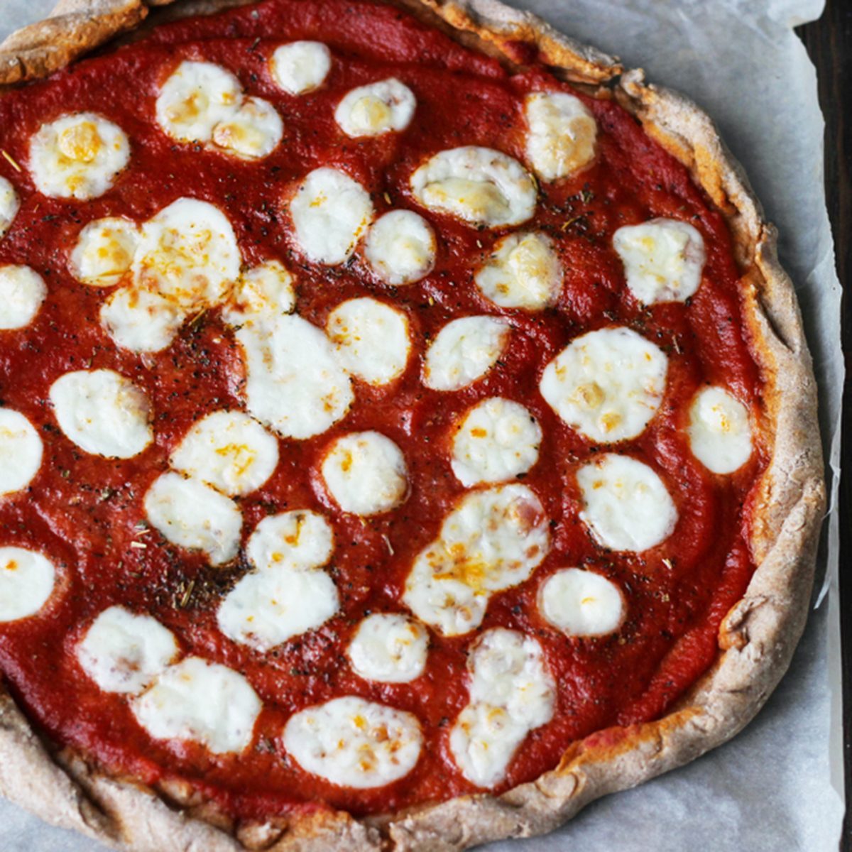 Wholegrain pizza Margherita with mozzarella on a brown wooden background; Shutterstock ID 1007894152; Job (TFH, TOH, RD, BNB, CWM, CM): RD