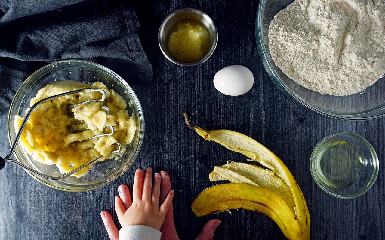 mashing bananas for healthy muffins with toddler