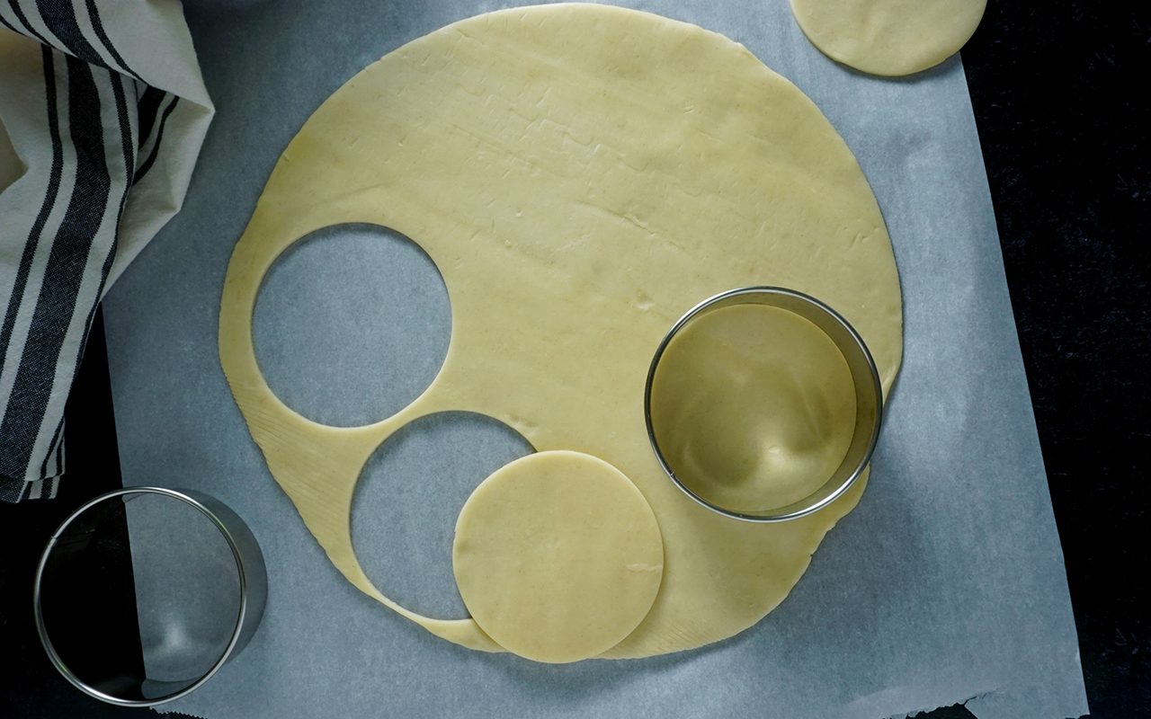 découpage de la pâte à tarte pour les mini-tartes dans un couvercle de bocal à conserve