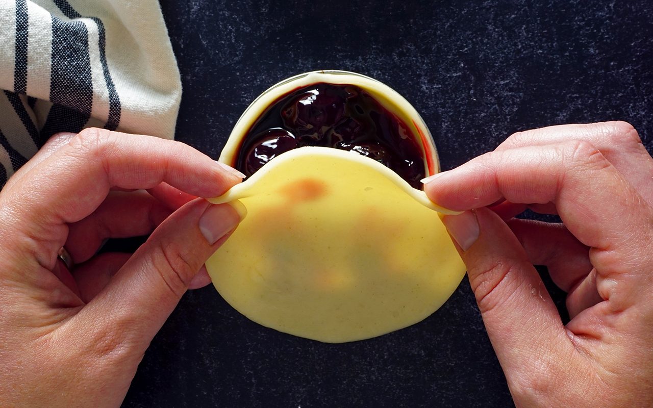 placing top crust onto pies