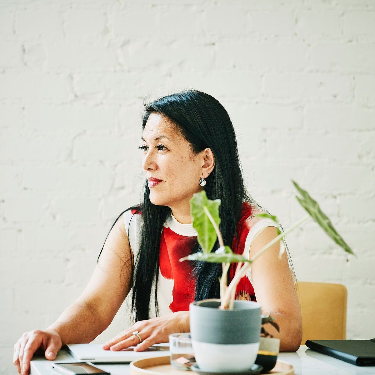 Woman sitting in home office with plant