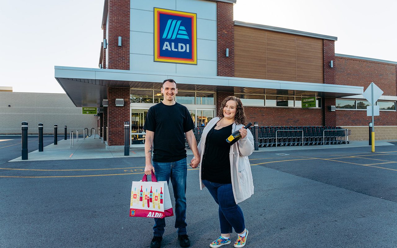 Aldi engagement couple in front of Aldi carrying groceries