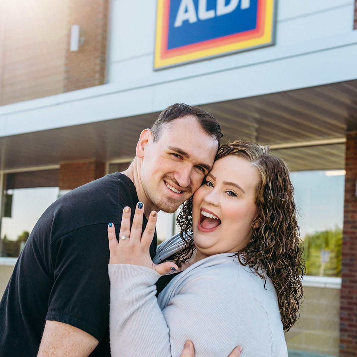 Aldi couple hugging in front of store