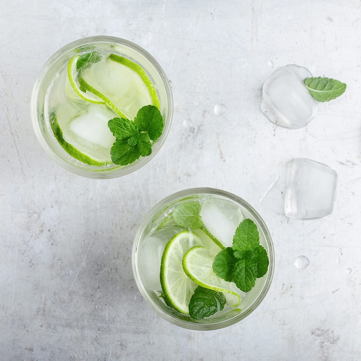 Cold drinks. Glasses of homemade iced cold lemonade with fresh lime, juice and mint leaves, refreshing summer drink, top view