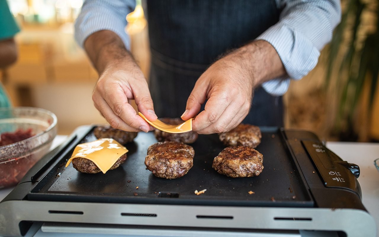https://www.tasteofhome.com/wp-content/uploads/2020/07/putting-cheese-on-burgers-1168380949.jpg