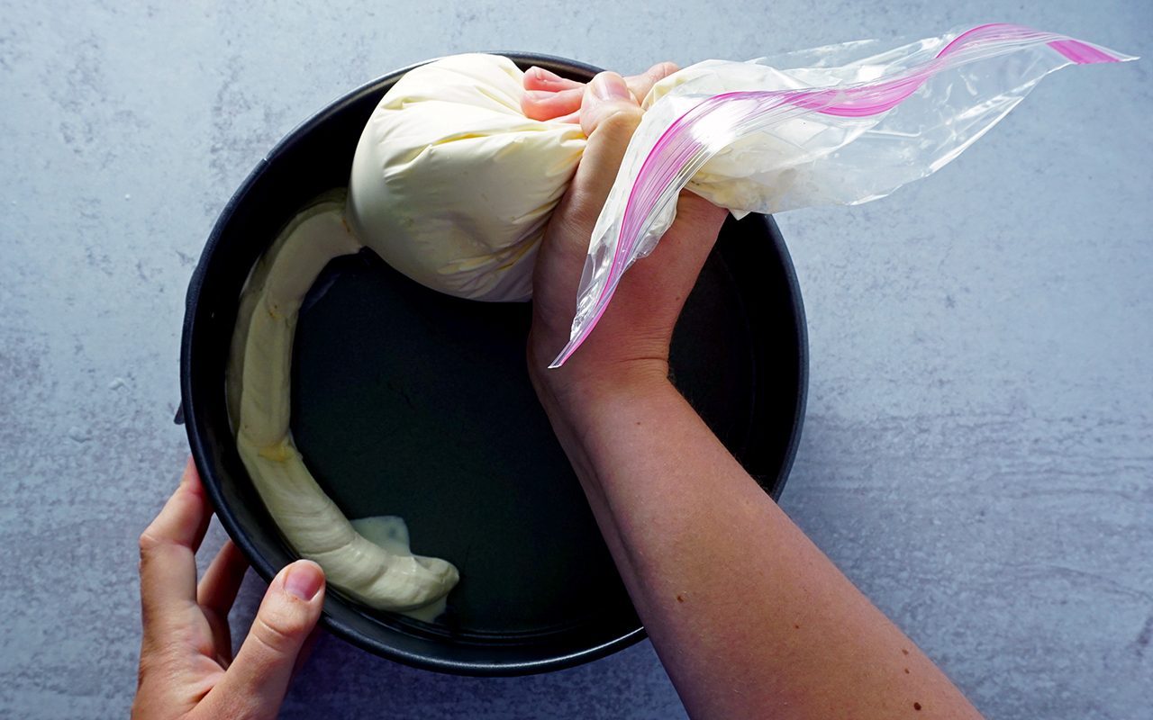 piping vanilla ice cream into a chilled springform pan to make ice cream cake