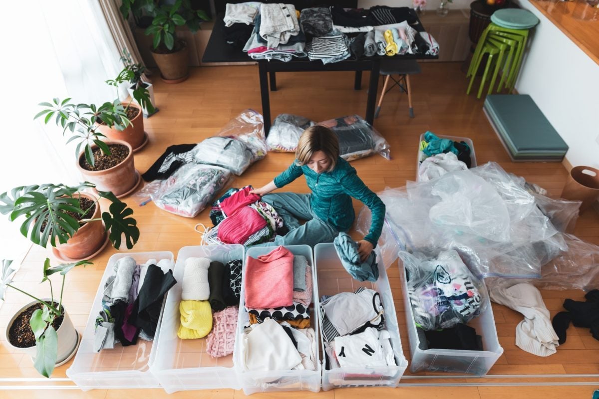 Woman organizes clothes in living room of her home