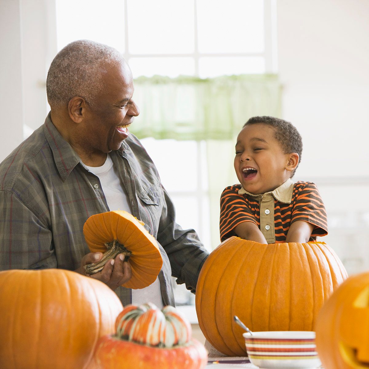 Grandfather and grandson carving a pumpkin