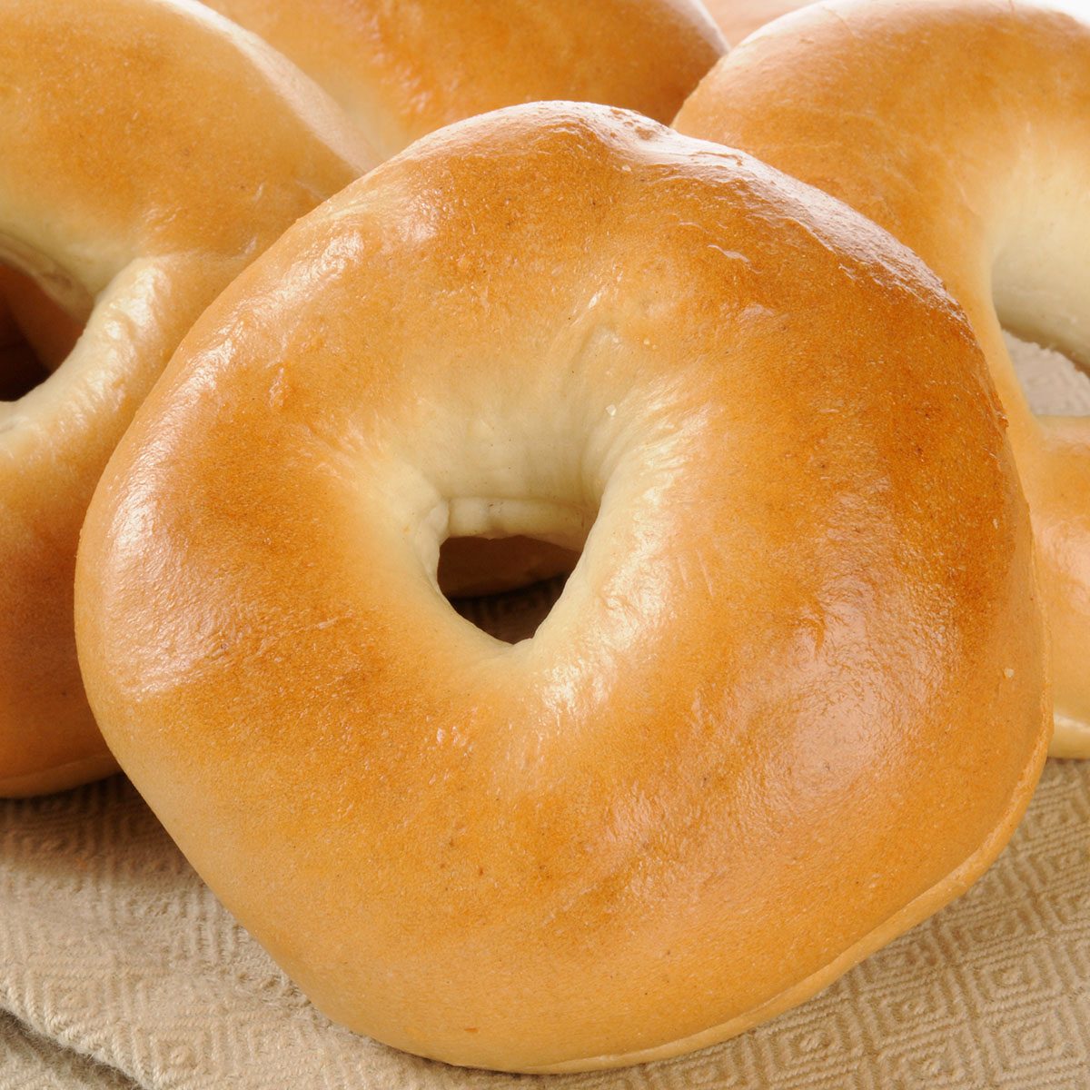 Golden sliced plain bagels on a napkin