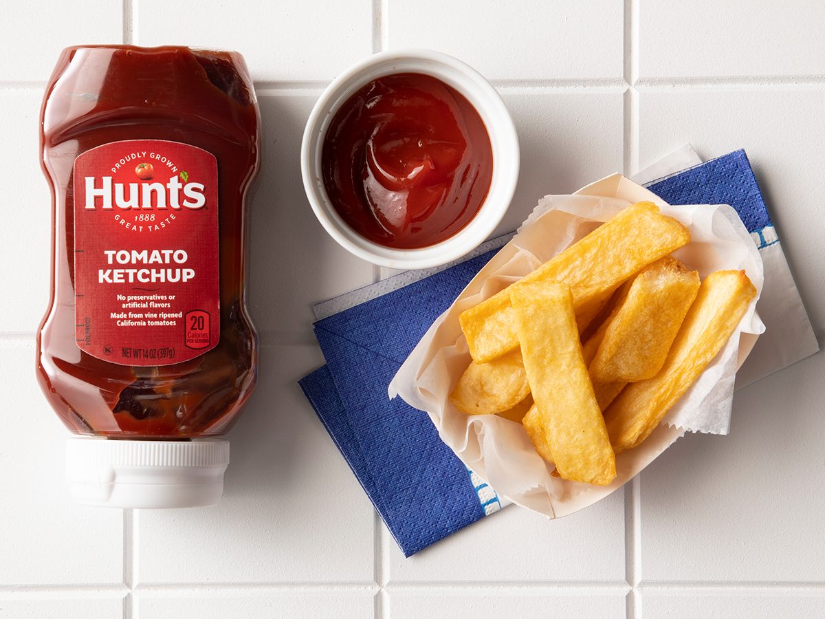 Overhead Shot Of Hunt's Ketchup In Bottle With Fries.