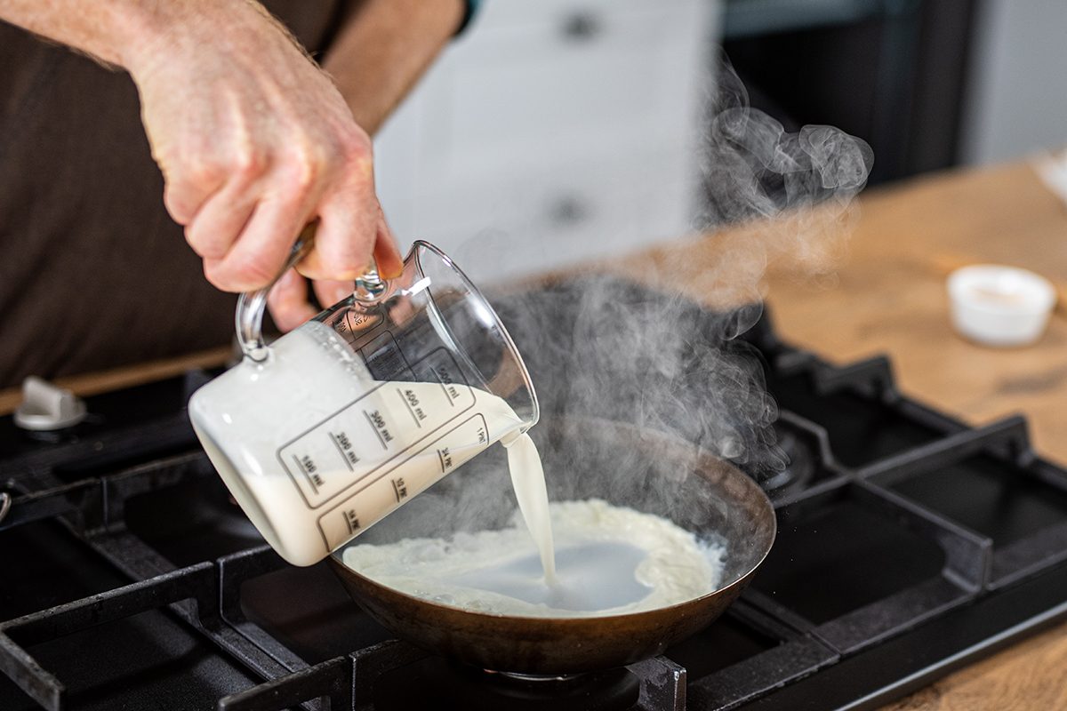 Chef Pouring Cream Into A Pan