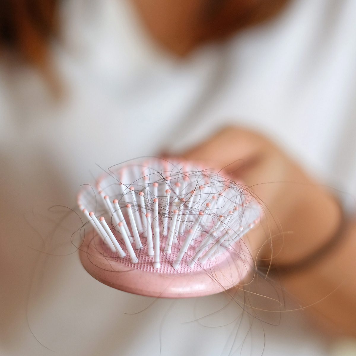 Midsection Of Woman Hairbrush With Fallen Hair