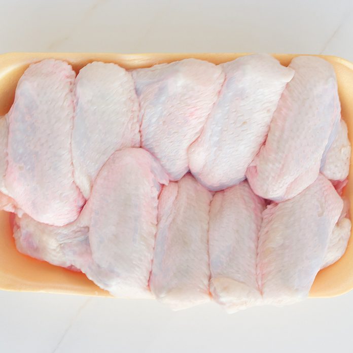 how to defrost chicken Chilled Chicken Wings In A Yellow Tray, Fresh Meat From The Store On A White Table. High Protein In Chicken