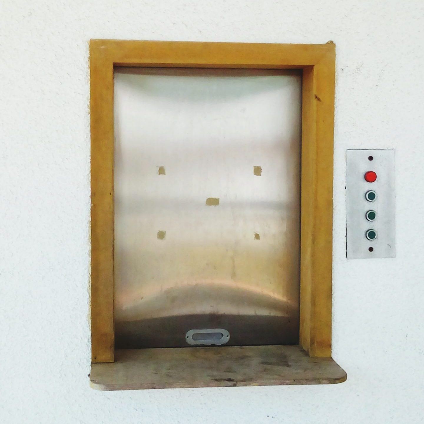 Close-Up Of Small Elevator On White Wall