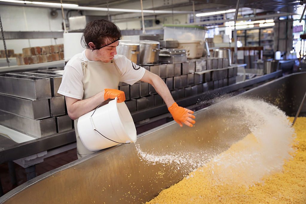 Trevor Hetzel salts a vat of Colby cheese at the Widmer's Cheese Cellars on June 27, 2016 in Theresa, Wisconsin