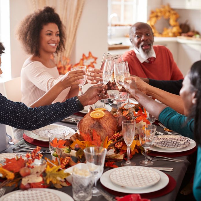 Multi generation family raise their glasses to make a toast at their Thanksgiving dinner table