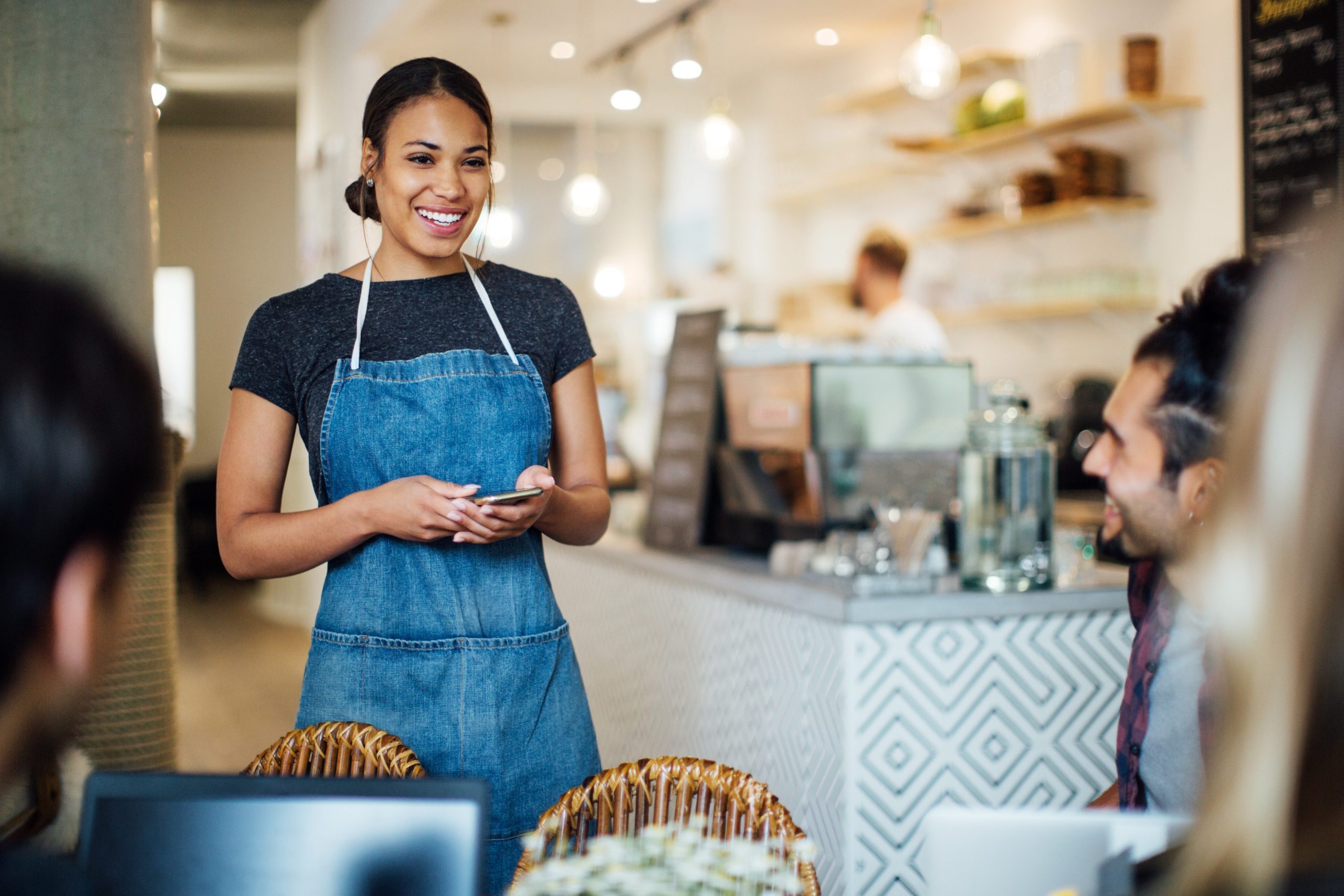 Beautiful Waitress At Cafe Taking Order From Customers