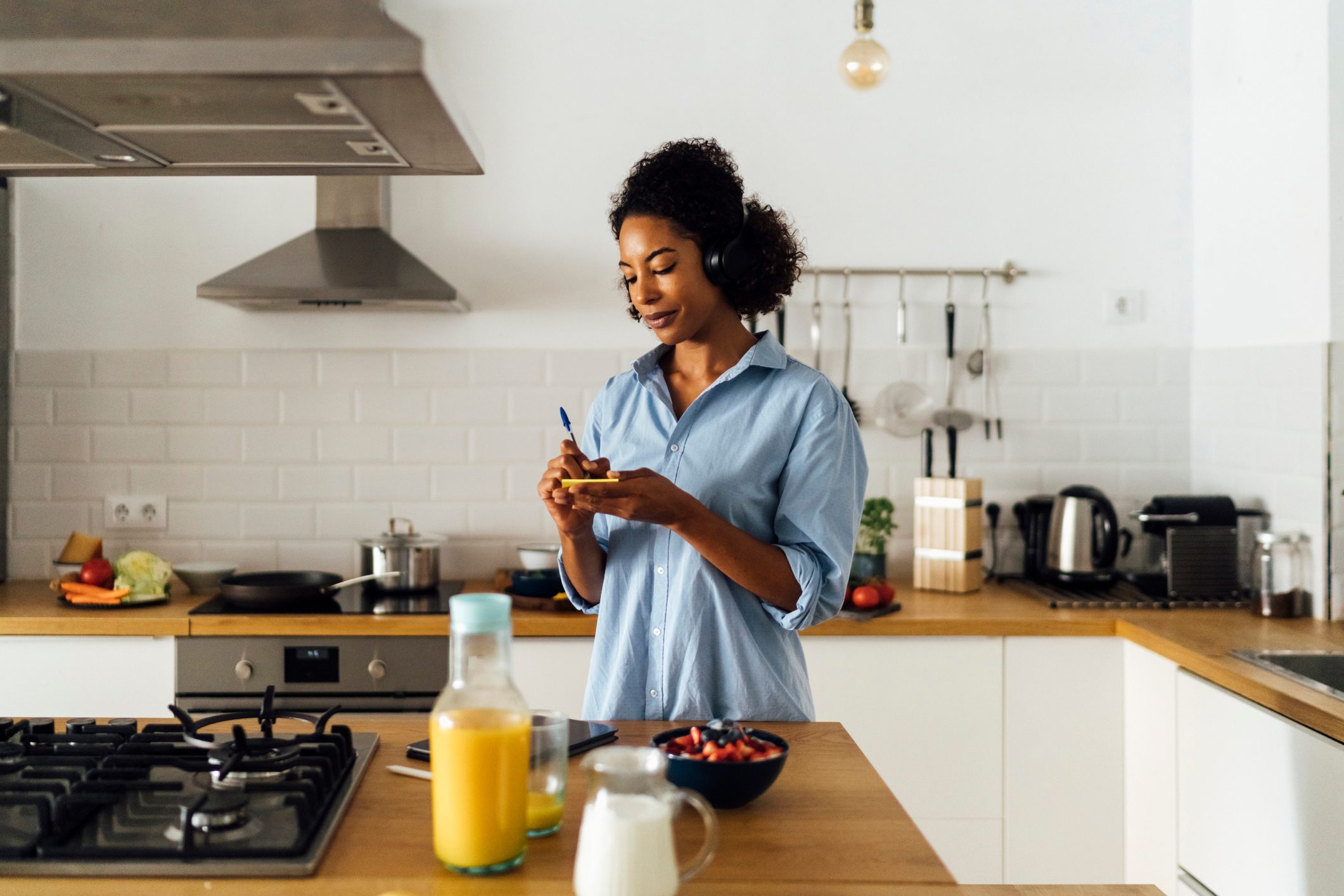 Woman in her kitchen in the morning, writing notes