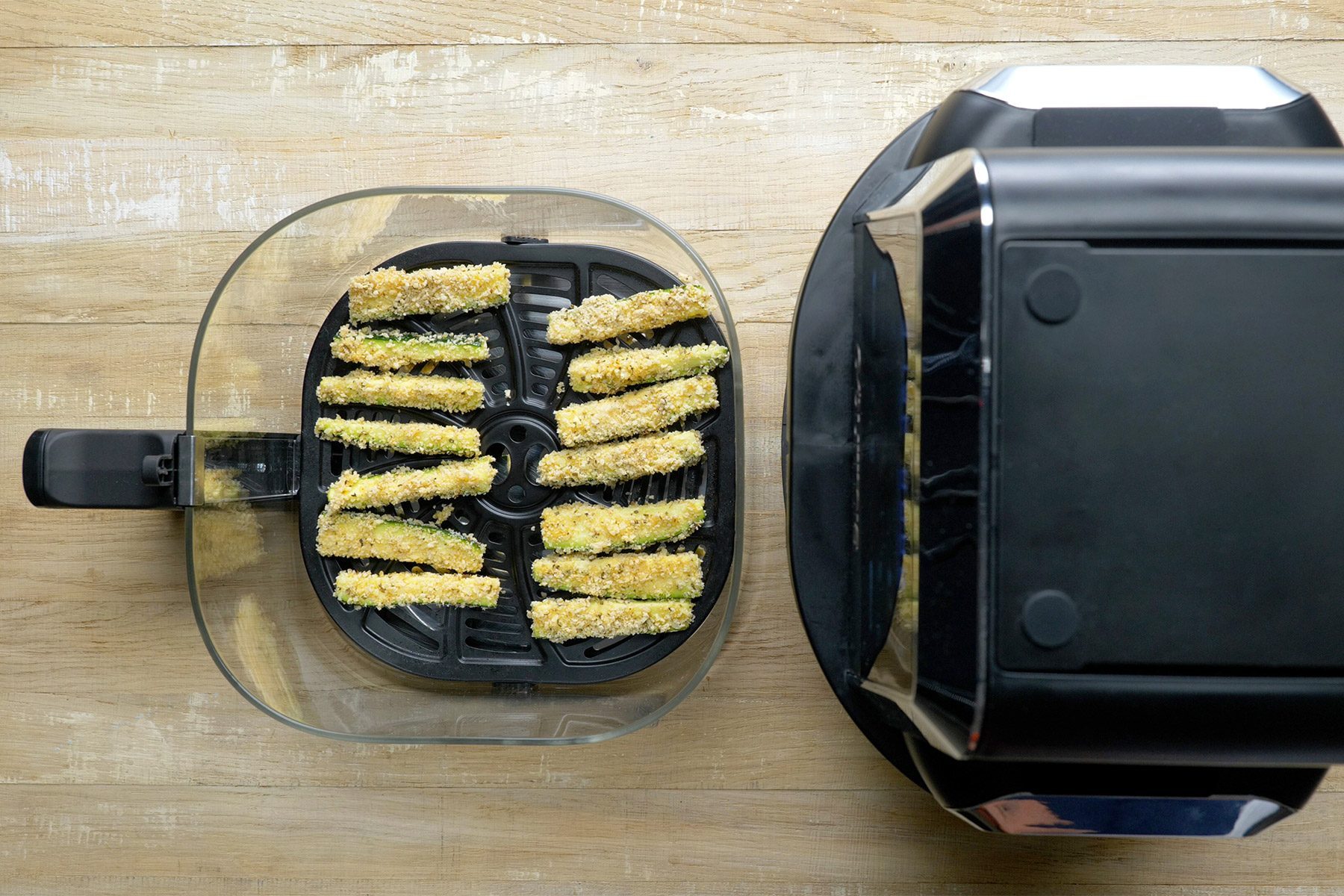 overhead shot of zuchhini slices placed in the air fryer basket