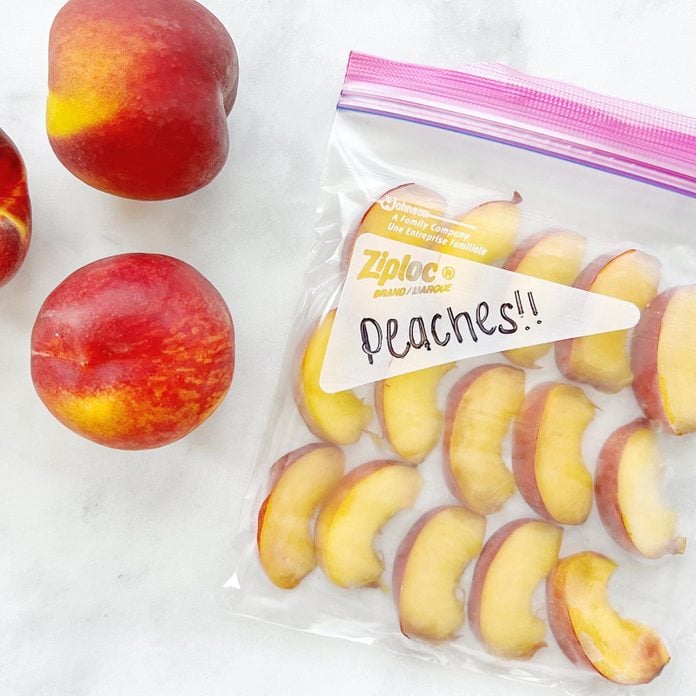 Frozen Peaches In Freezer Bag next to three fresh peaches