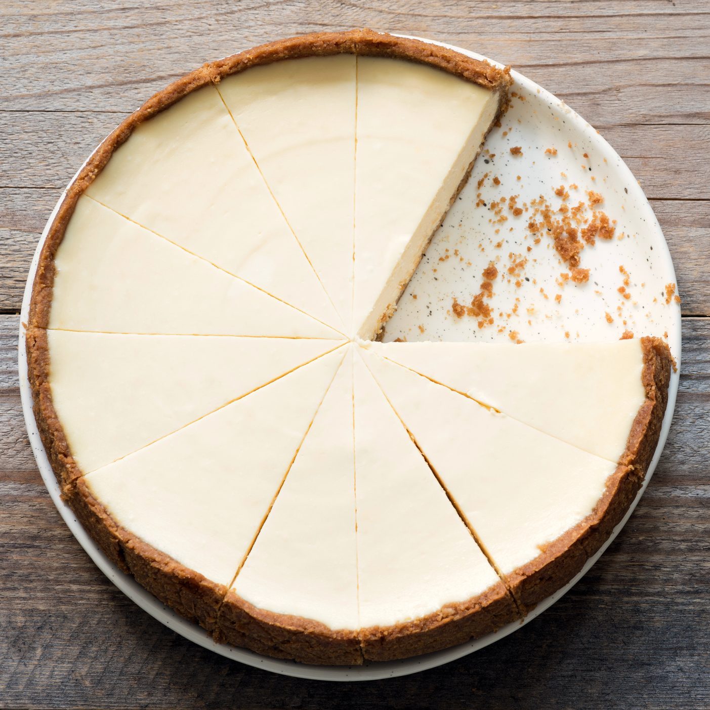 New York Cheesecake or Classic Cheesecake sliced on rustic wood, top view