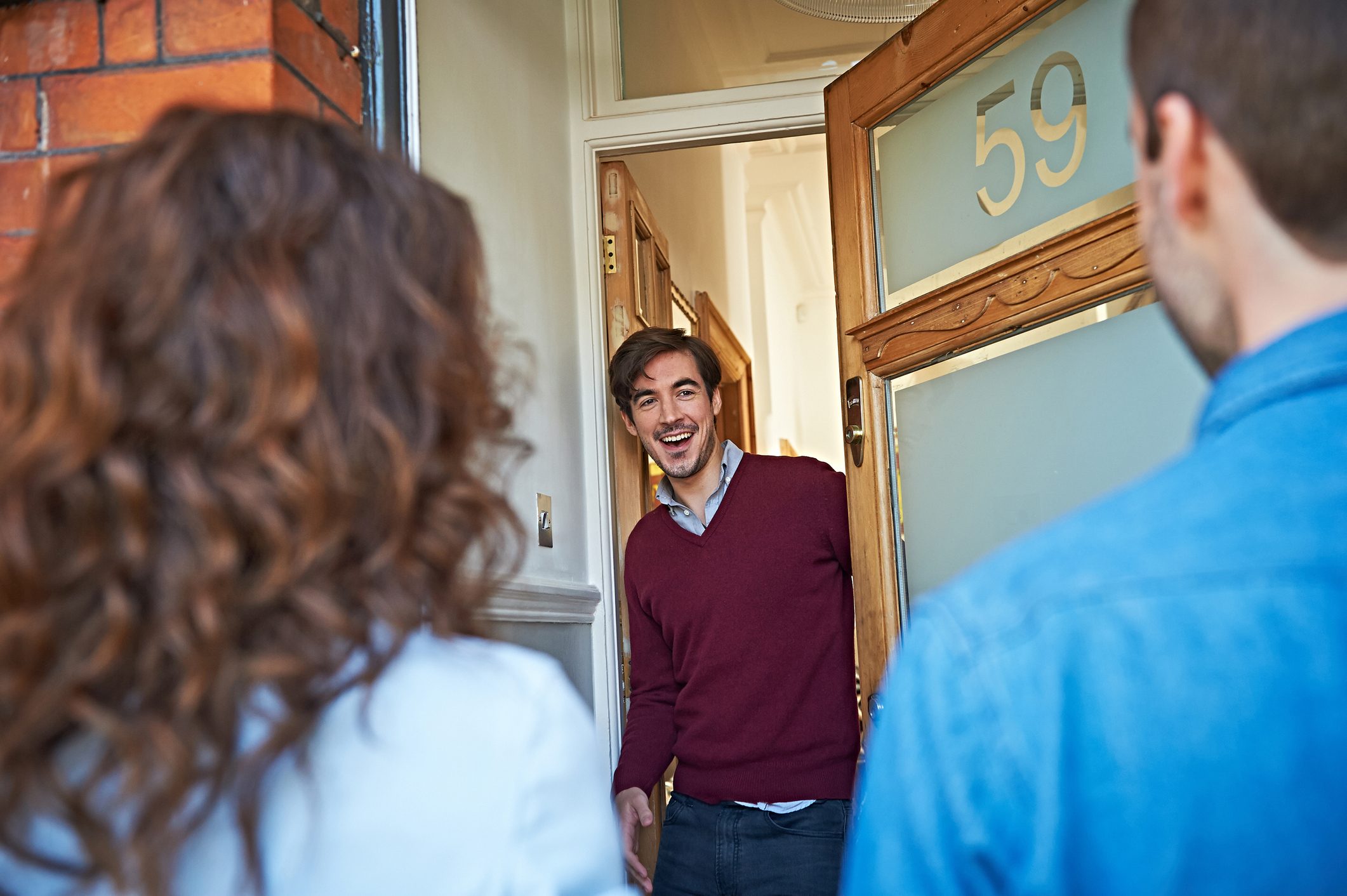 Man welcoming friends at front door